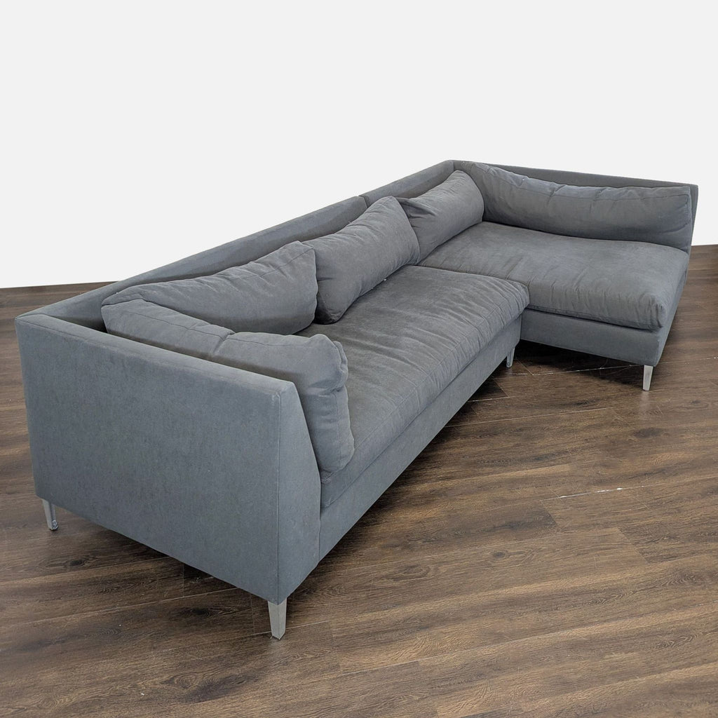 Modern gray sectional sofa by Crate & Barrel, featuring sturdy metal legs and soft, comfortable cushions for relaxing.