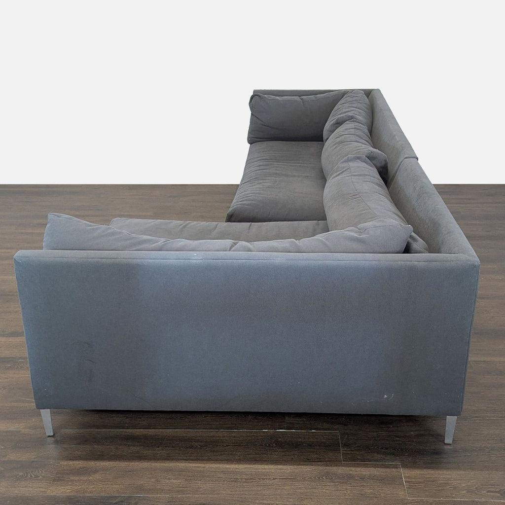 Sectional sofa in versatile gray from Crate & Barrel, with sleek design, plush back cushions, and stylish metal legs.