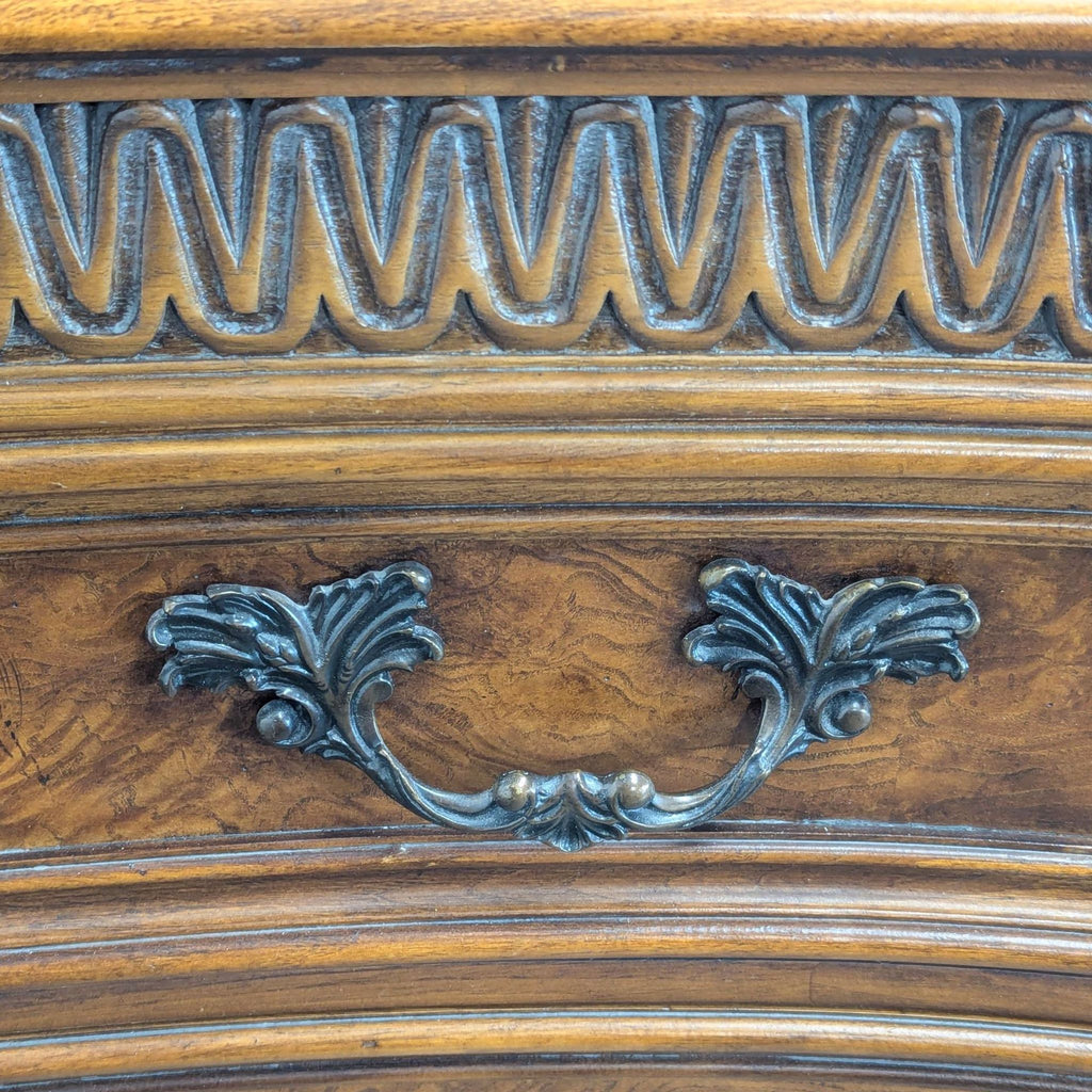 Close-up of decorative metal handle and carved wood trim on a Drexel Heritage dresser drawer.