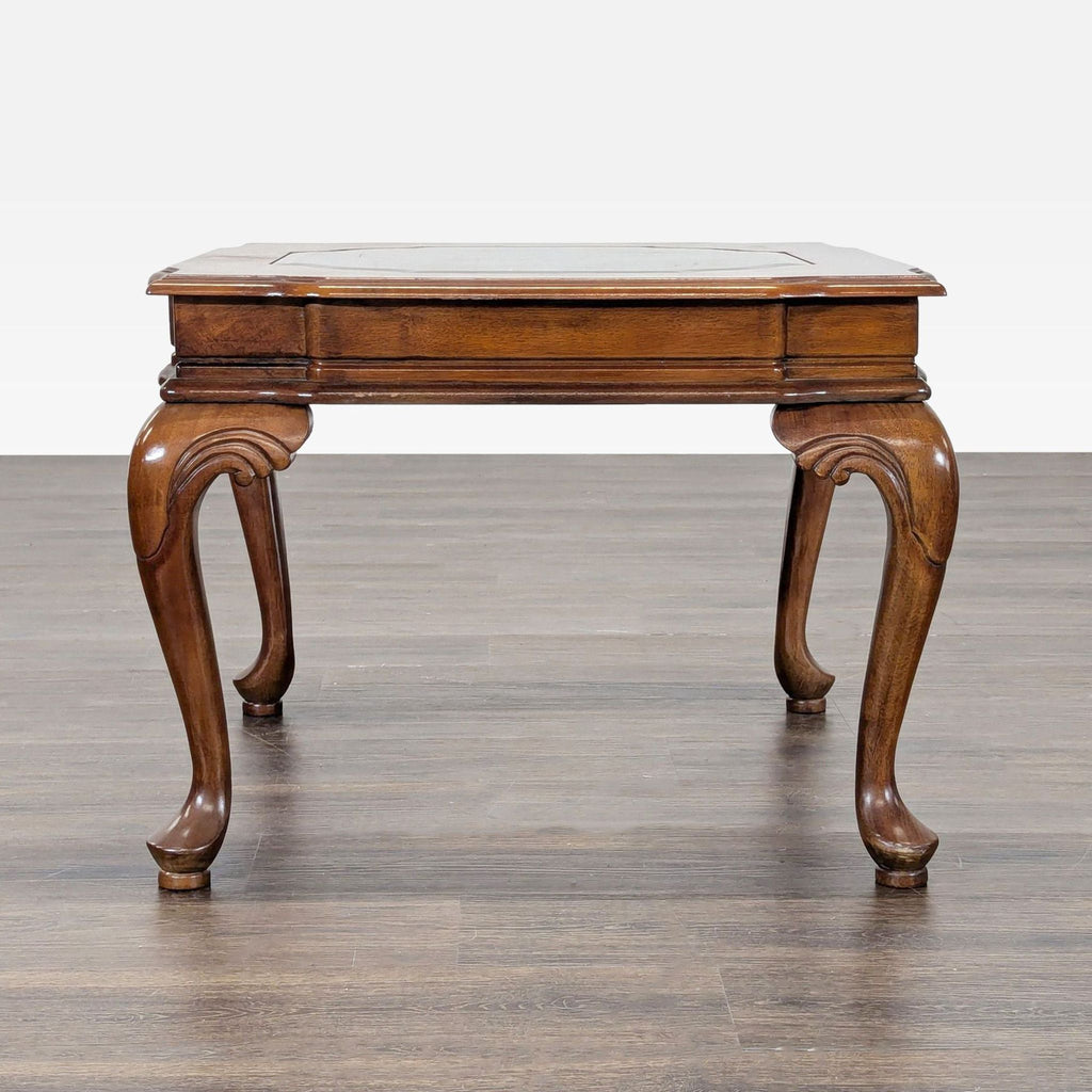 Elegant carved end table featuring cabriole legs and a glass top insert.