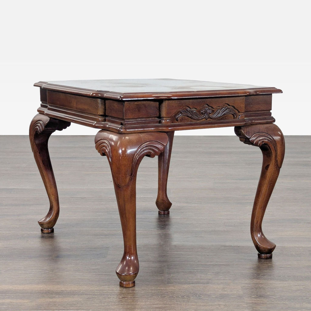 Antique-style table showing inlaid top detail and gracefully curved cabriole legs.