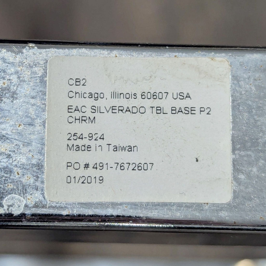 Product label for CB2 dining table, model EAC Silverado TBL BASE P2 CHRM, showing manufacturing details.