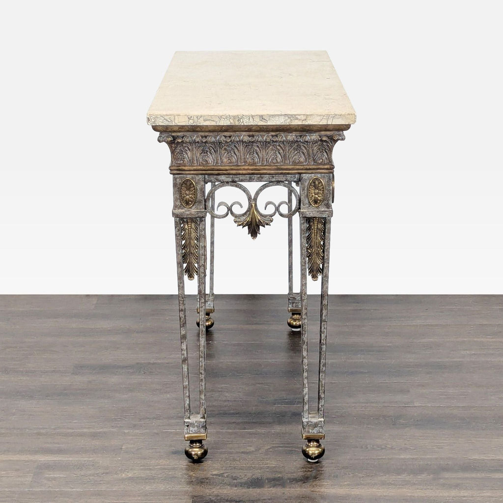 Side profile of a Maitland-Smith console table featuring a marble top and decorative iron with brass trim.  