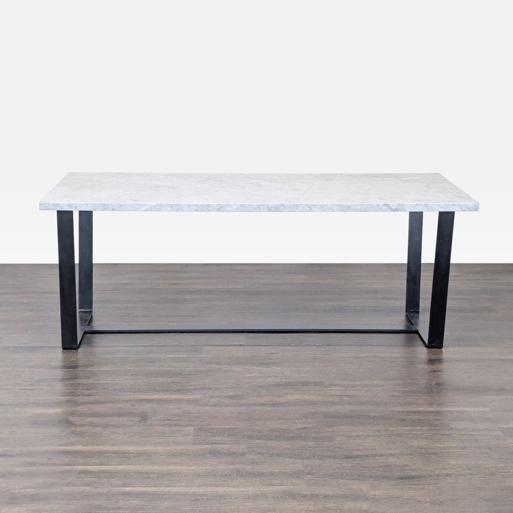 3. Sleek dining table with marble surface and blackened steel sled-style base, seats up to eight people.