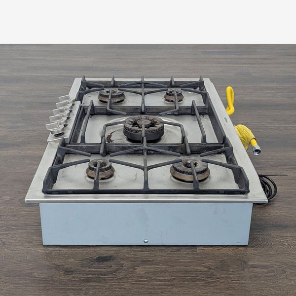 Gaggenau stainless steel gas cooktop with 5 burners and central high-power burner, featuring cast iron grates.