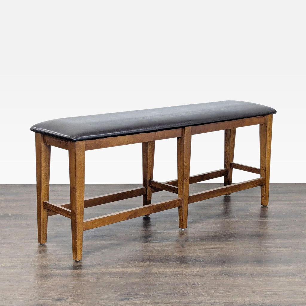 1. Wooden bench with a black cushioned seat and four sturdy legs, shown on a wood floor.
