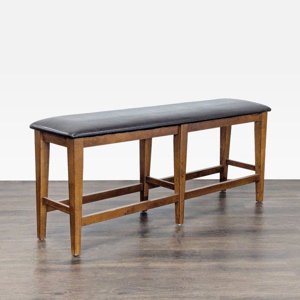 1. Wooden bench with a black cushioned seat and four sturdy legs, shown on a wood floor.