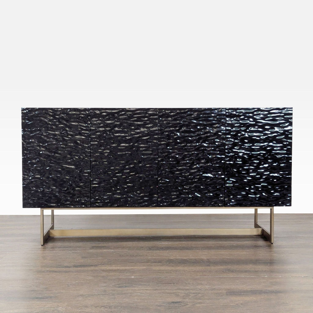CB2 black textured sideboard with brass metal base, four doors, and interior shelves for ample storage.