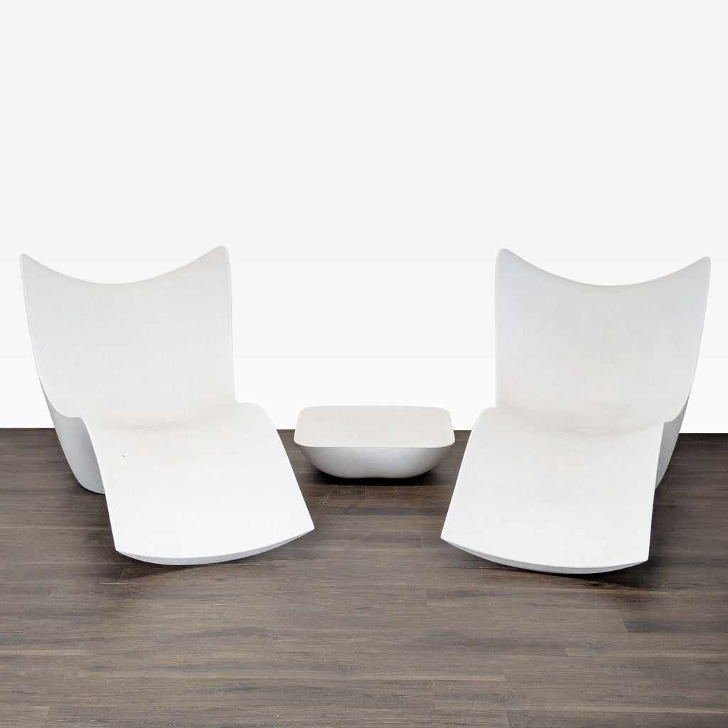 Set of two white Vondom lounge chairs and table, modern ergonomic design, on wood floor.