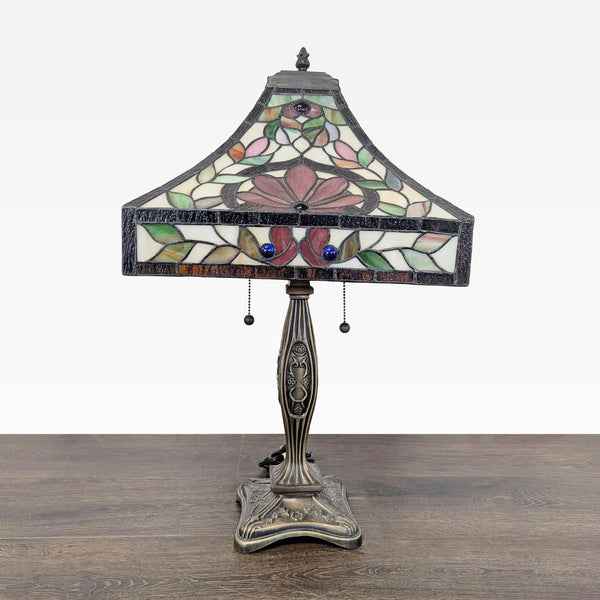 Stained glass table lamp with colorful floral design and engraved metal base, perfect for classic decor.