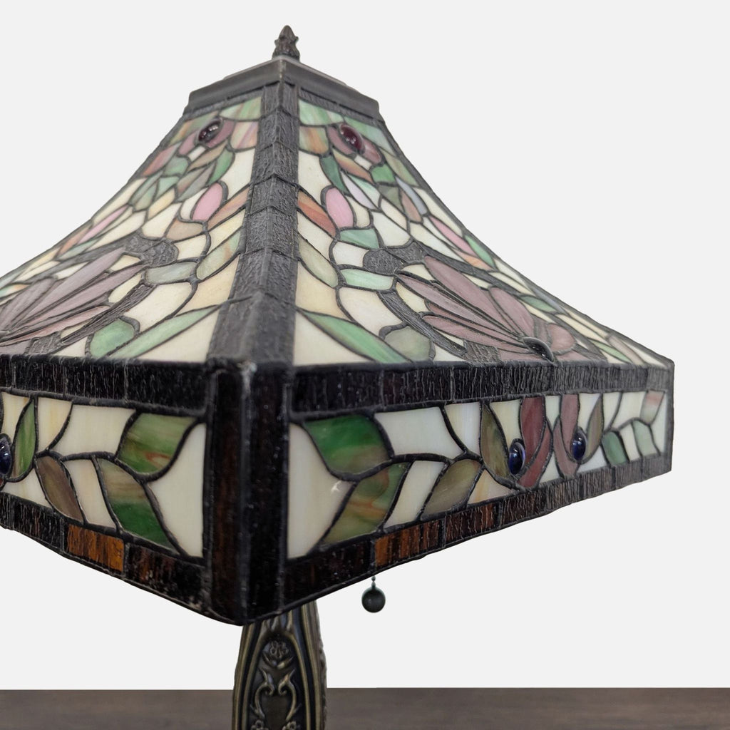 Classic metal base table lamp with intricate floral stained glass shade, adding artistry to any room.