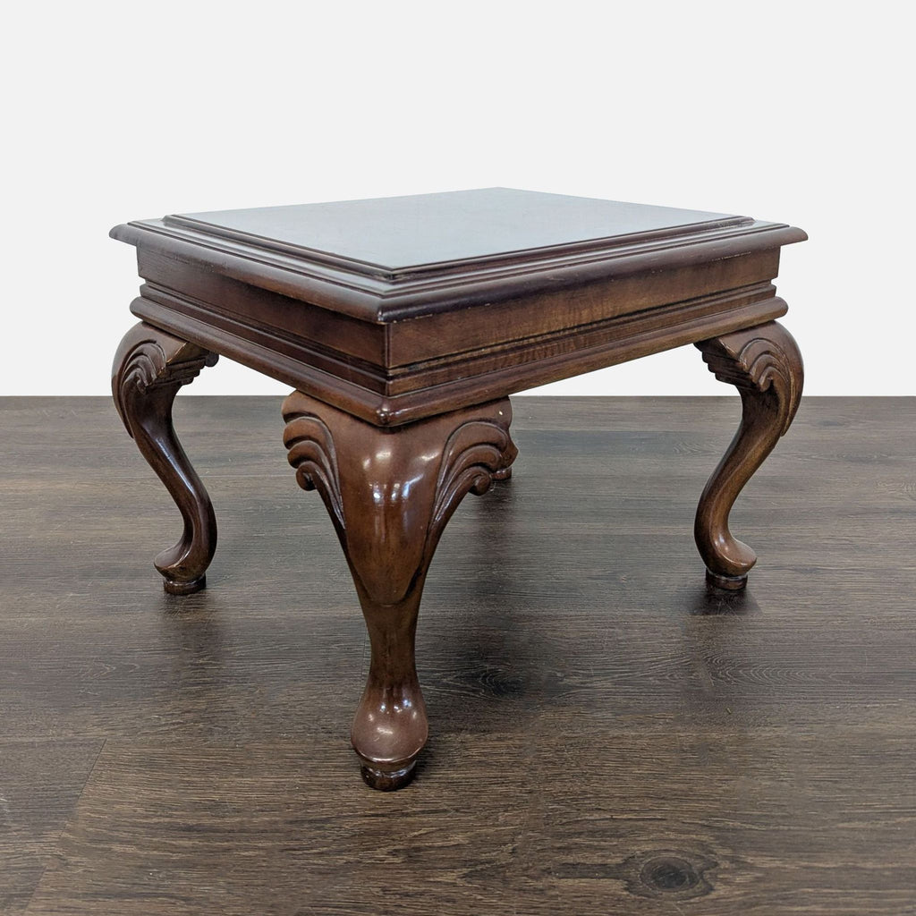 Neutral fabric ottoman featuring a flip-top wood table and intricately carved cabriole legs for classic style.