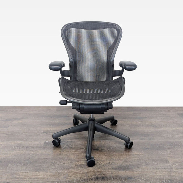 Herman Miller Aeron ergonomic office chair with mesh seat, adjustable arms, and rolling casters.