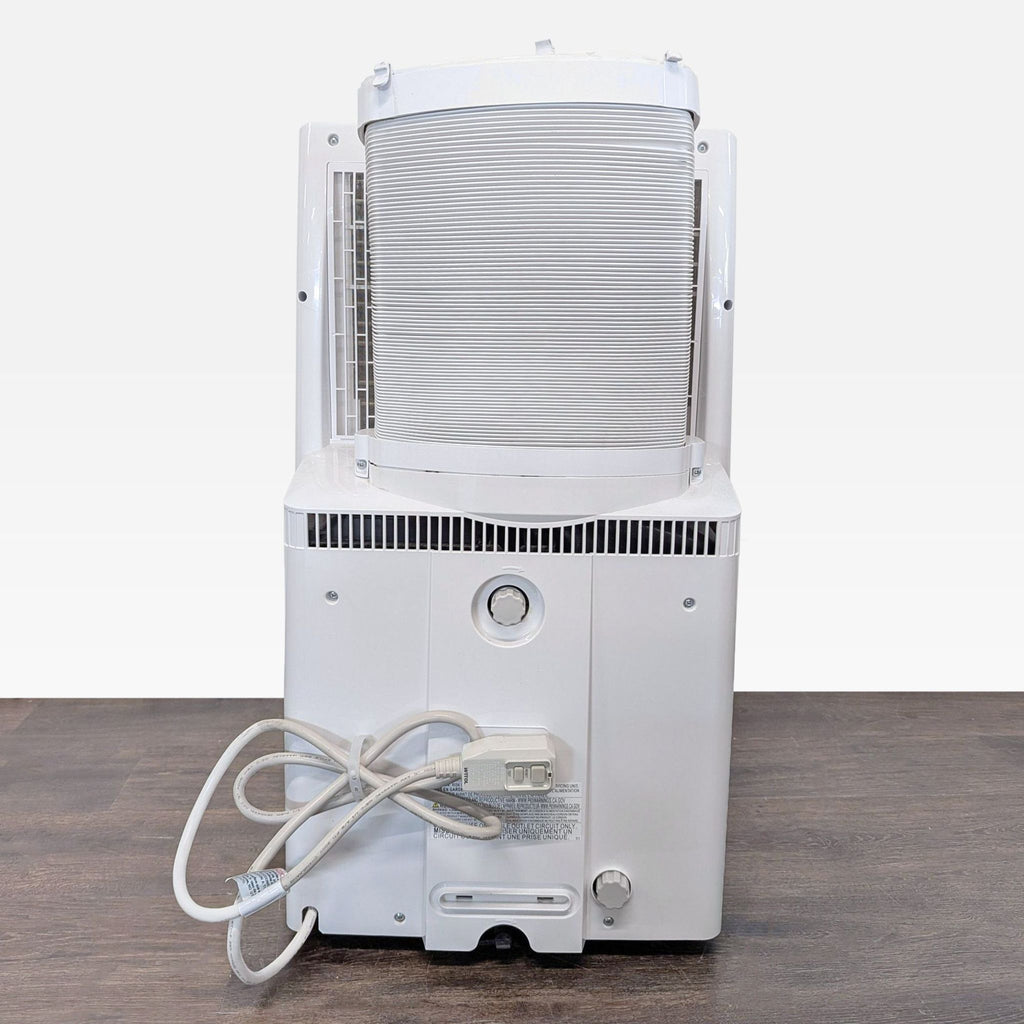 Compact Toshiba AC unit with built-in fan, modern look, and portable wheels, suitable for bedroom use.  