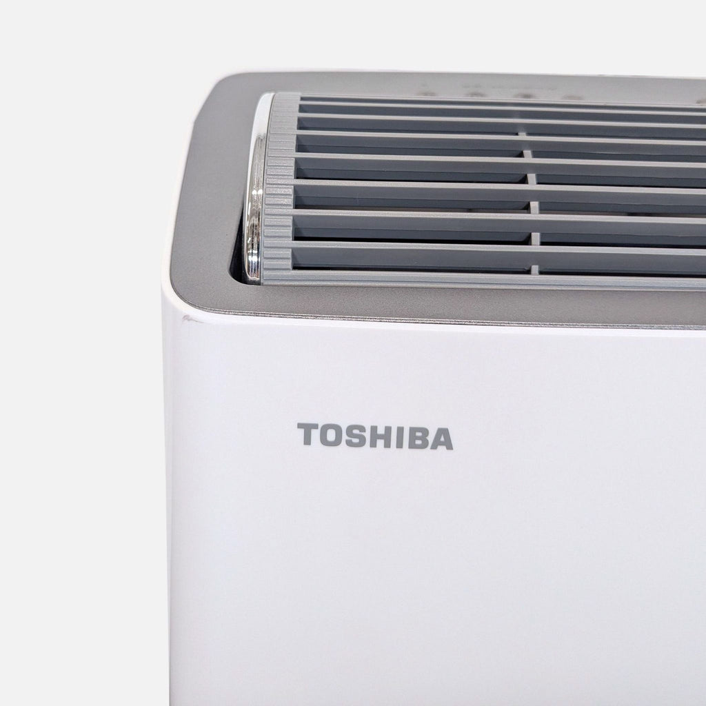 Close-up of Toshiba air conditioner controls and vent, highlighting simple interface and efficient cooling features.