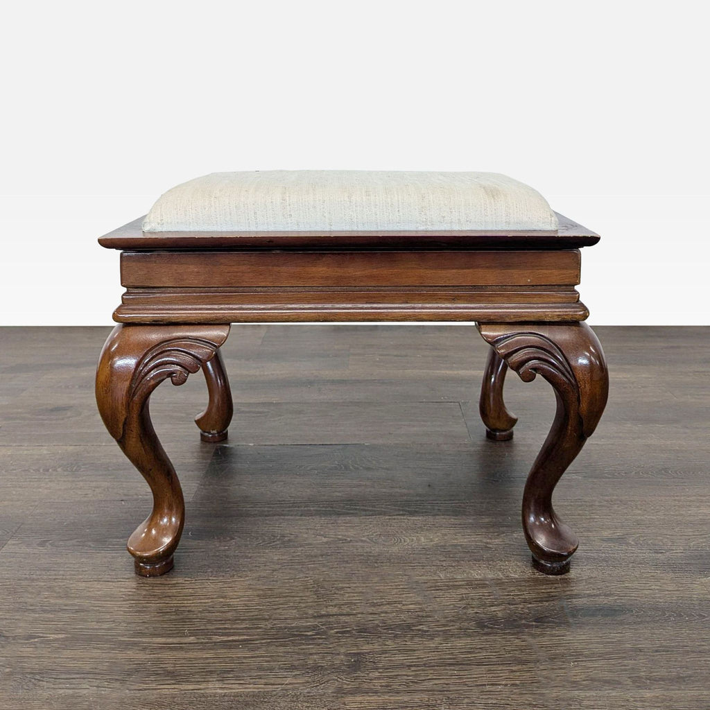 Versatile ottoman with removable cushion, wood tabletop underside, carved cabriole legs, and neutral upholstery.