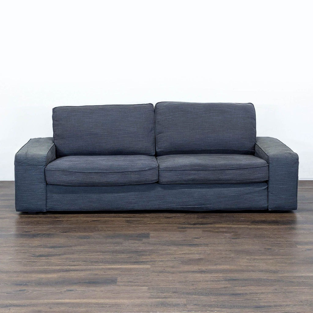 Ikea 3-seat sofa in dark gray with wide armrests, modern style, and spacious seating for living rooms.