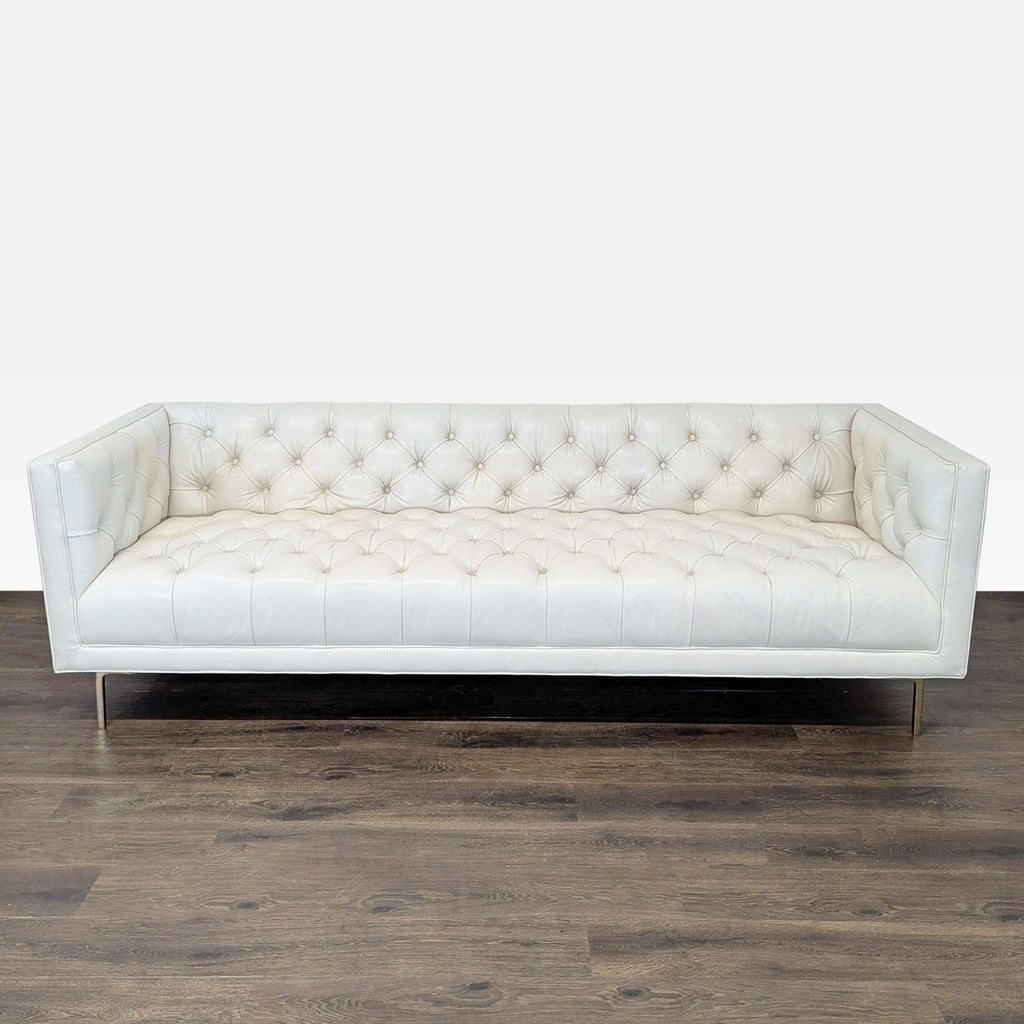 Modern 3-seat sofa by Elite Leather Company in ivory leather, deep tufted design, and slim metal legs.  