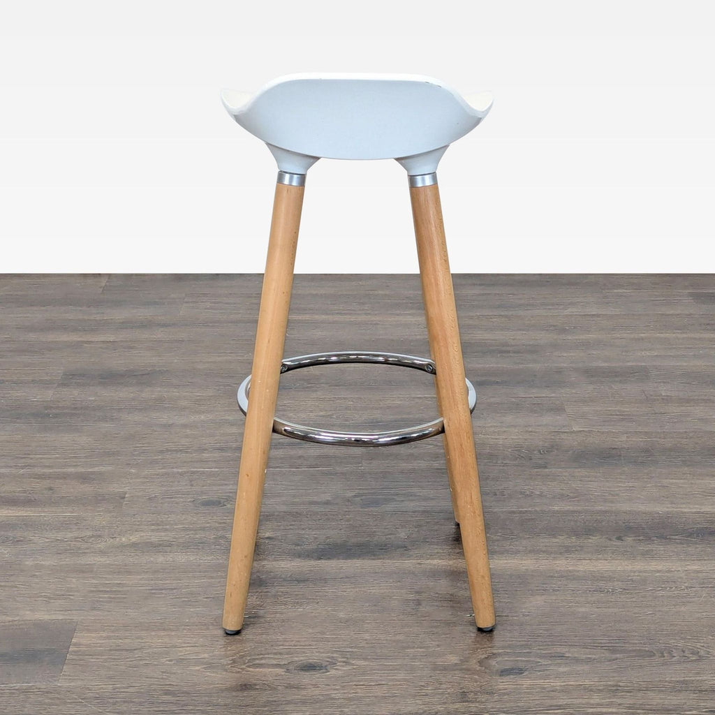 Sleek bar stool from Stools, Ottomans & Benches; white ABS seat, beechwood legs, and chrome ring footrest.