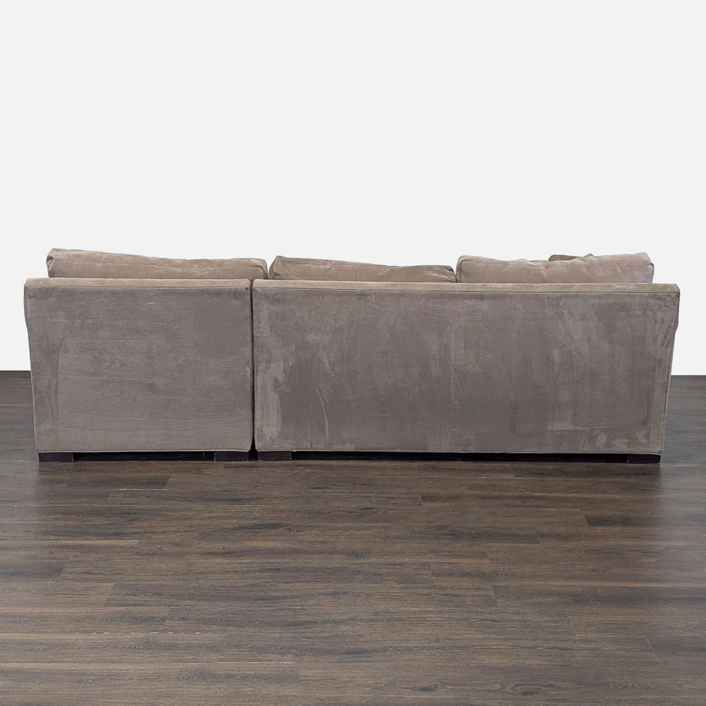 3. Back view of a Crate & Barrel sectional sofa, highlighting its sturdy build and plush back cushions.