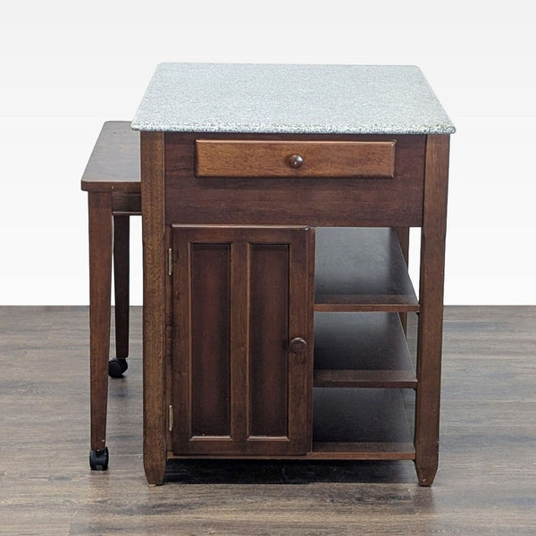 Kitchen island with granite top, open storage shelves, and extendable wheeled table for extra workspace.