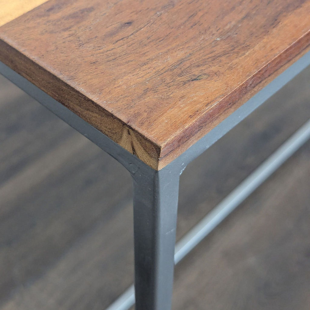 Side table featuring a wooden surface and minimalist metal base by CB2.