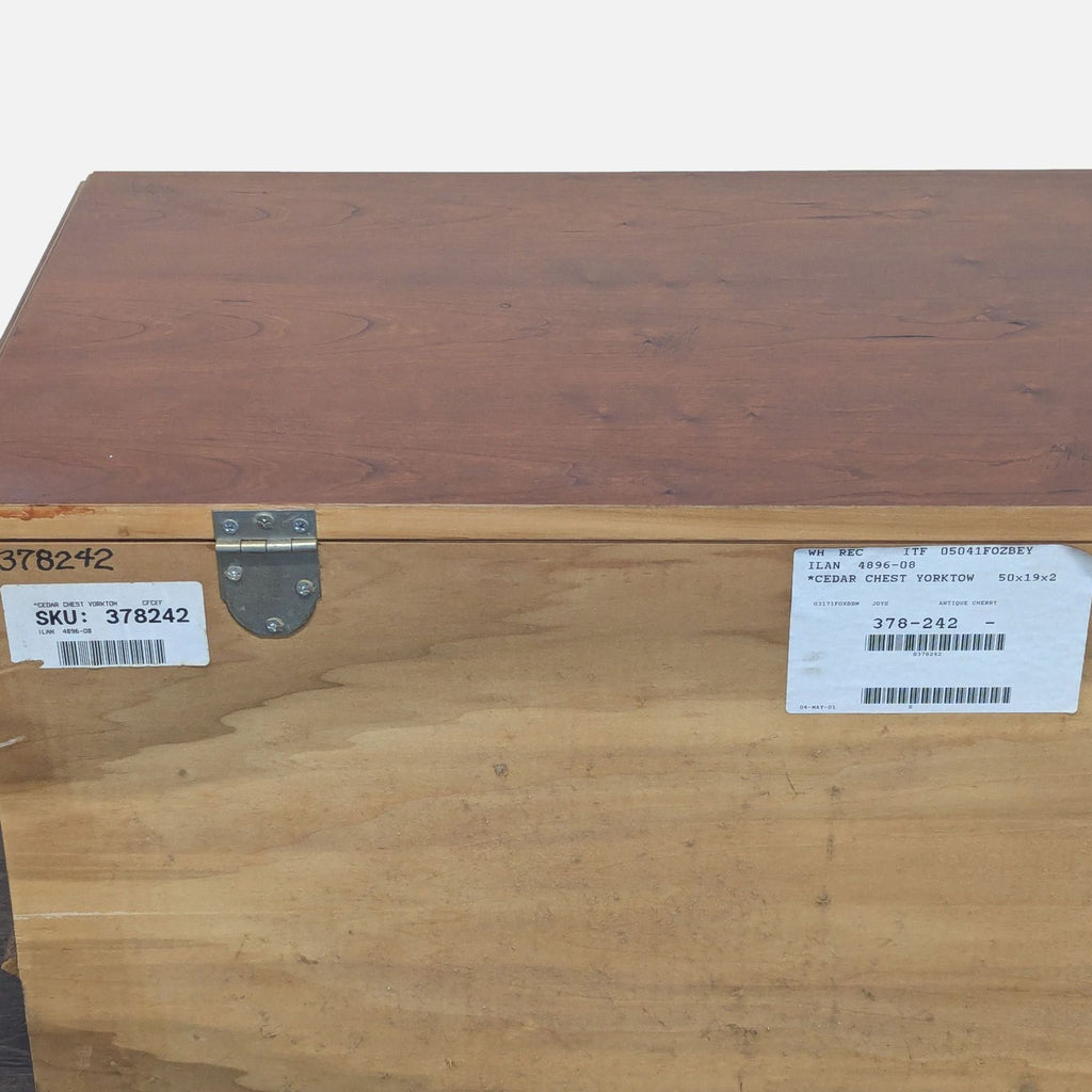 Close-up of the back side of a Lane trunk, showing SKU and product labels near a metal hinge.