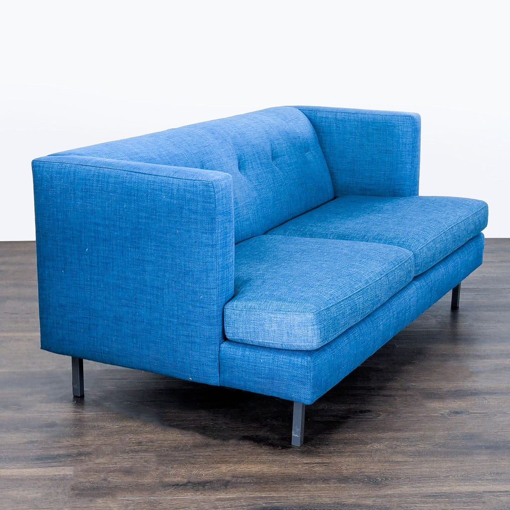 2. Side angle of a bold blue CB2 loveseat, showing slim metal legs and clean, modern design.