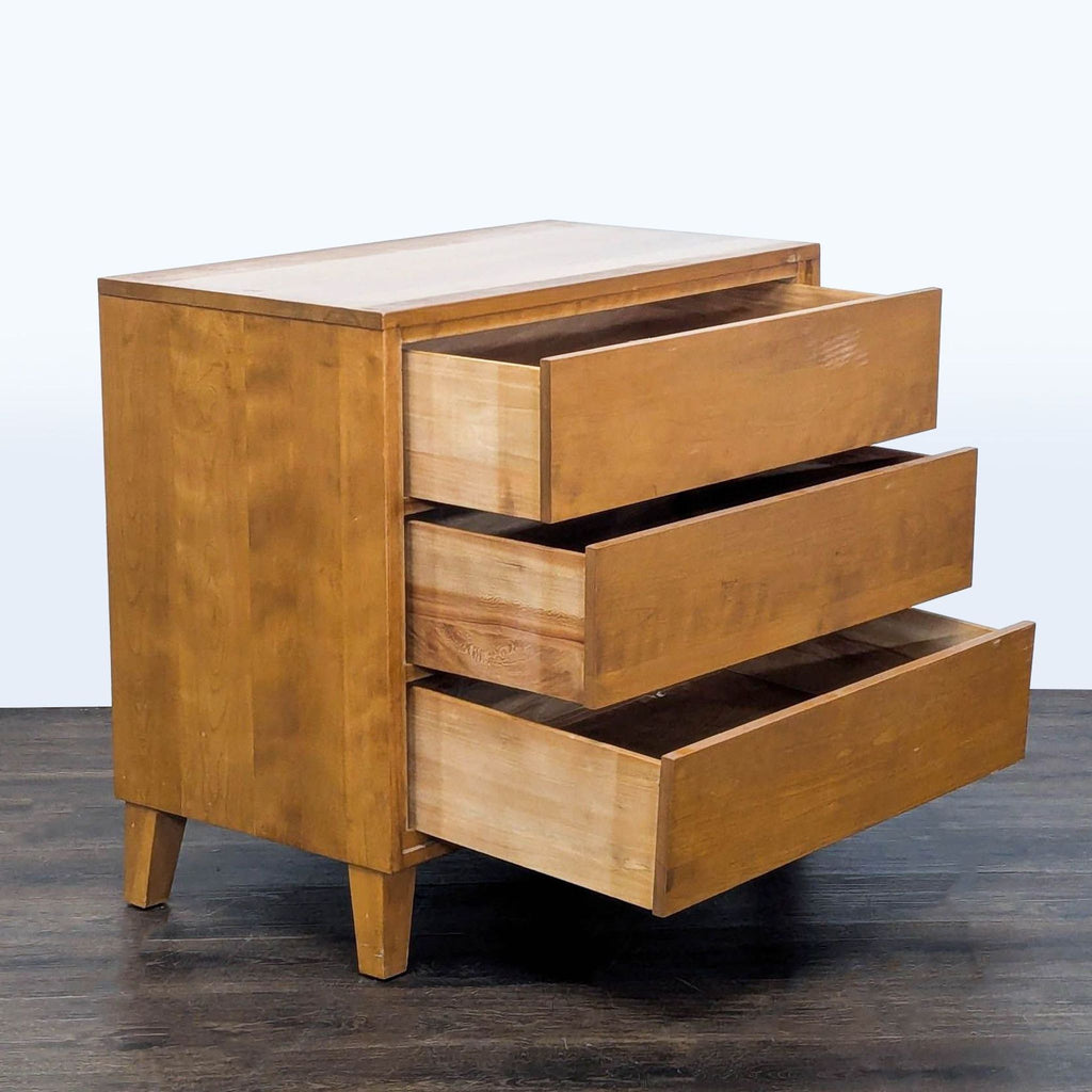 Side angle of a Conant Ball three-drawer solid wood dresser with drawers open, showing spacious storage.  