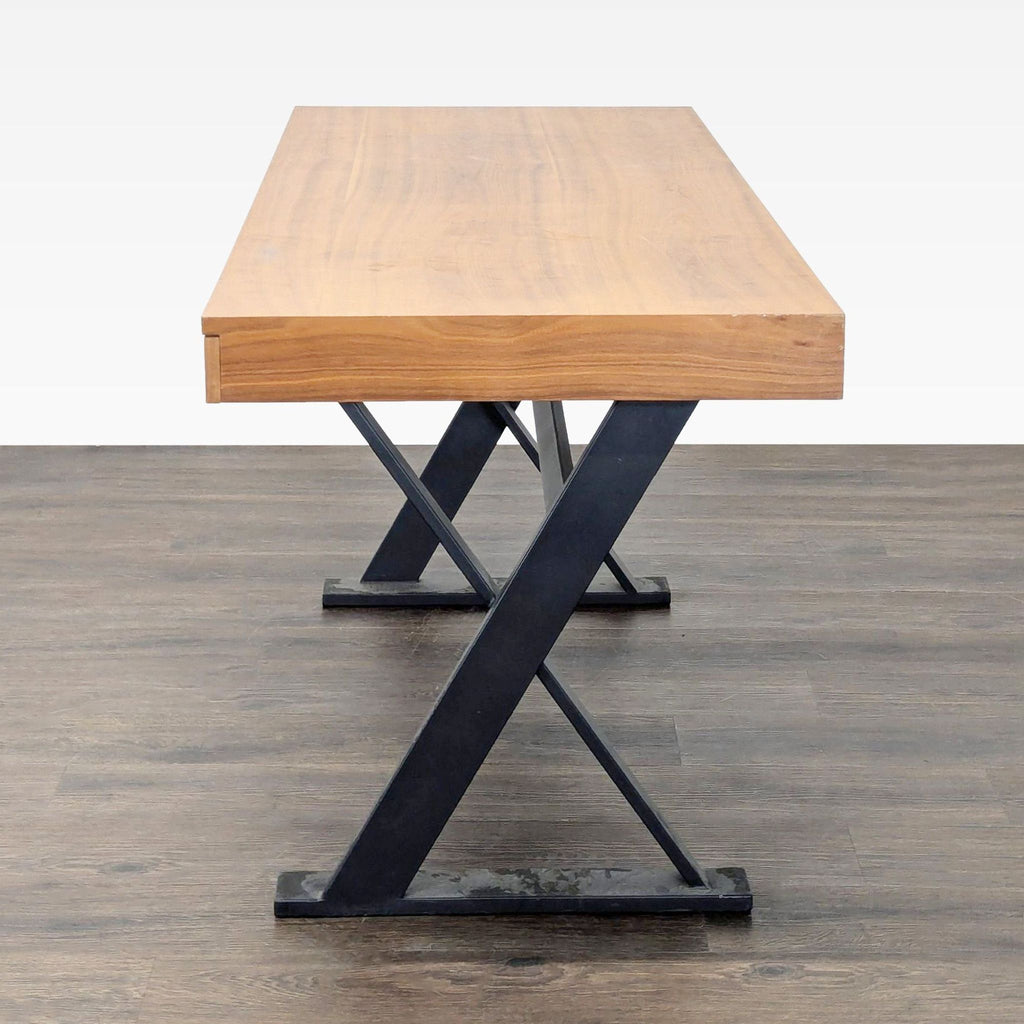 3. Side view of Moe's modern desk highlighting the thick wood top and sturdy X-shaped black metal support legs.