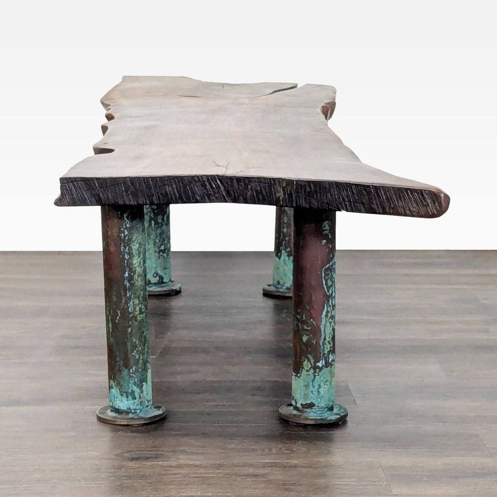 Close-up of oxidized copper legs on a coffee table, showing blue-toned patina details.  
