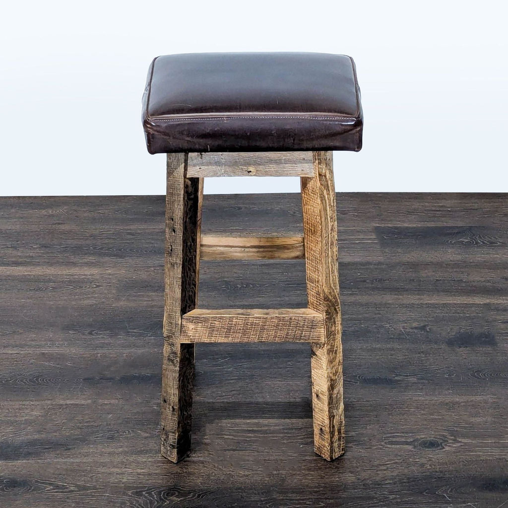 Timeless Journey rustic stool featuring barnyard wood base and stitched leather cushion.