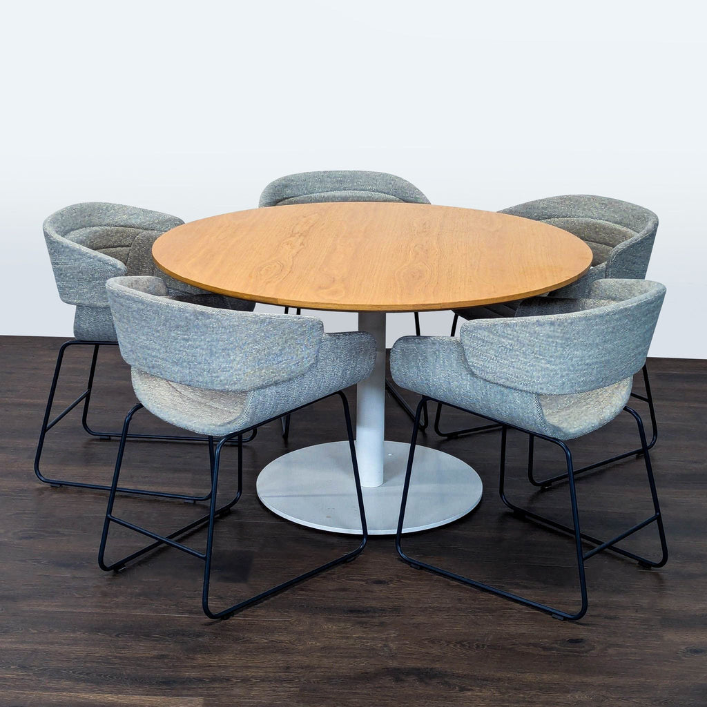 Blu Dot dining set featuring a round wooden table with white metal base and five modern upholstered chairs.