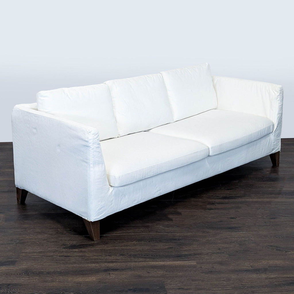 Modern Ikea 3-seater sofa in bright white, clean lines, wooden base, comfy and stylish for any living room.