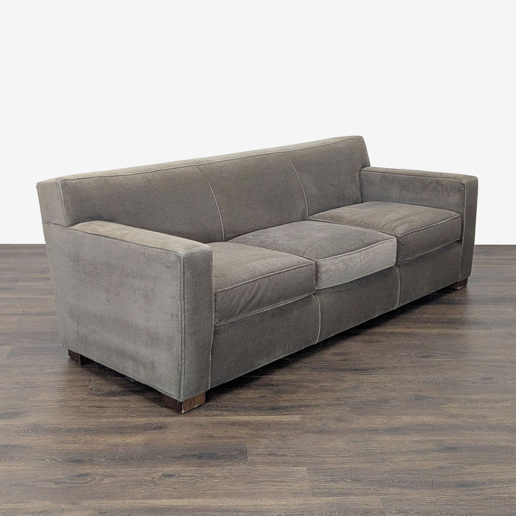 Gray upholstered Room & Board sofa comfortably seats three, offering a versatile and sturdy modern seating option.