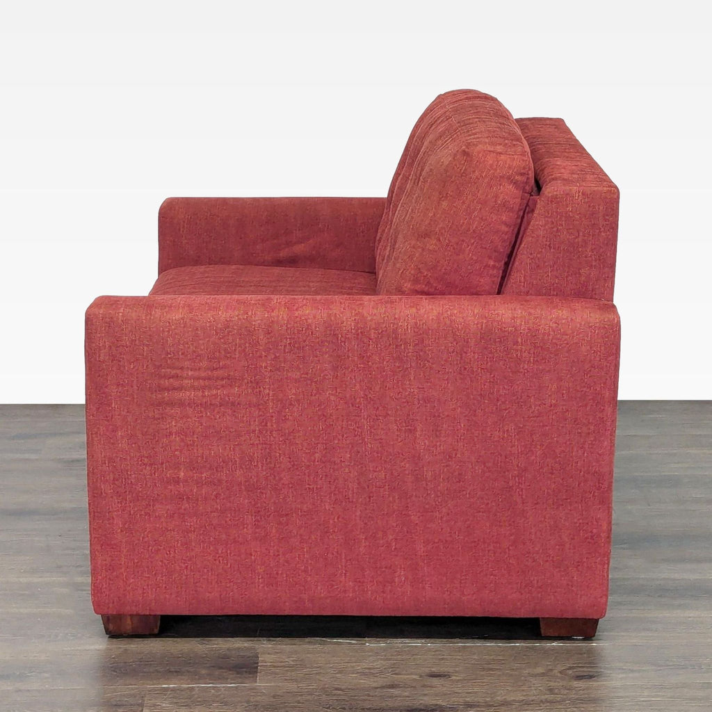 Modern red sleeper sofa by Crate & Barrel, featuring soft cushions and a space-saving pull-out bed design.