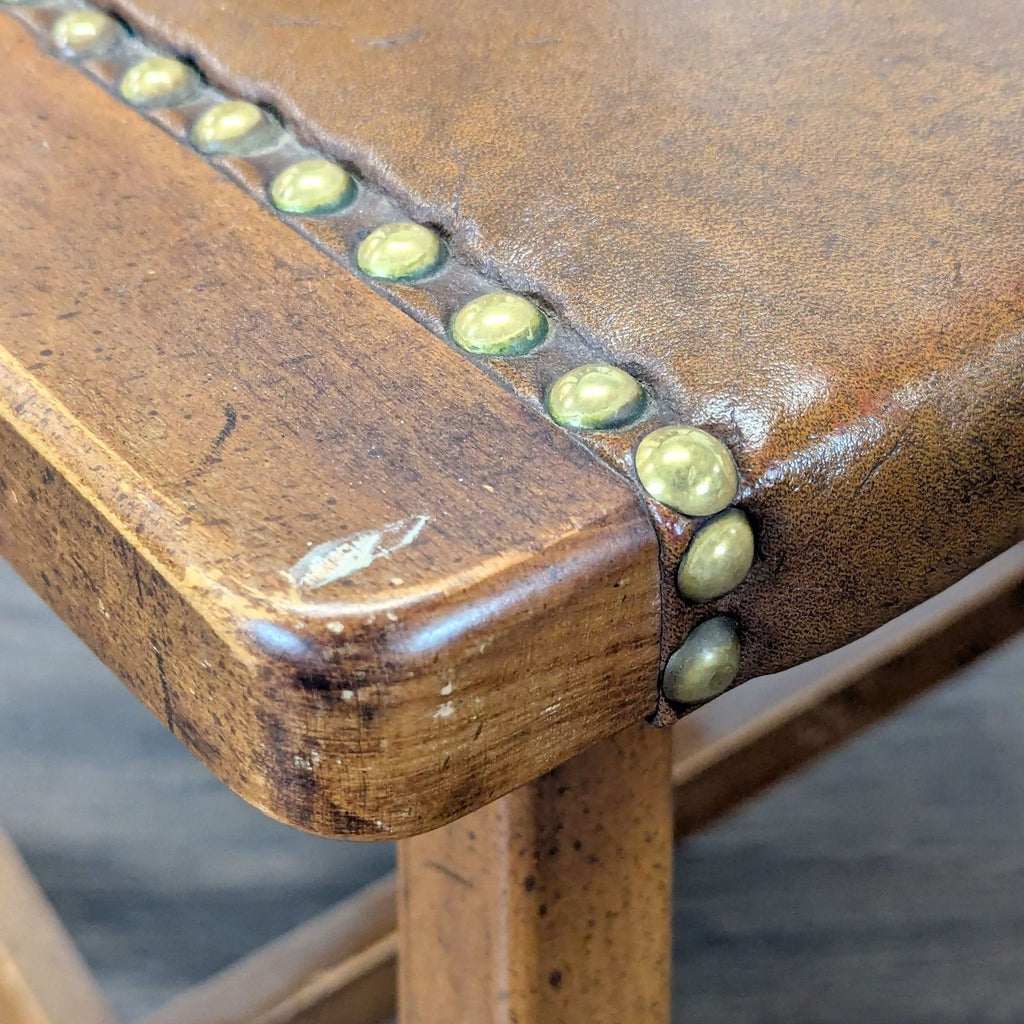 3. Close-up of a dining set chair, showing wood grain details and decorative brass studs on the seat edge.