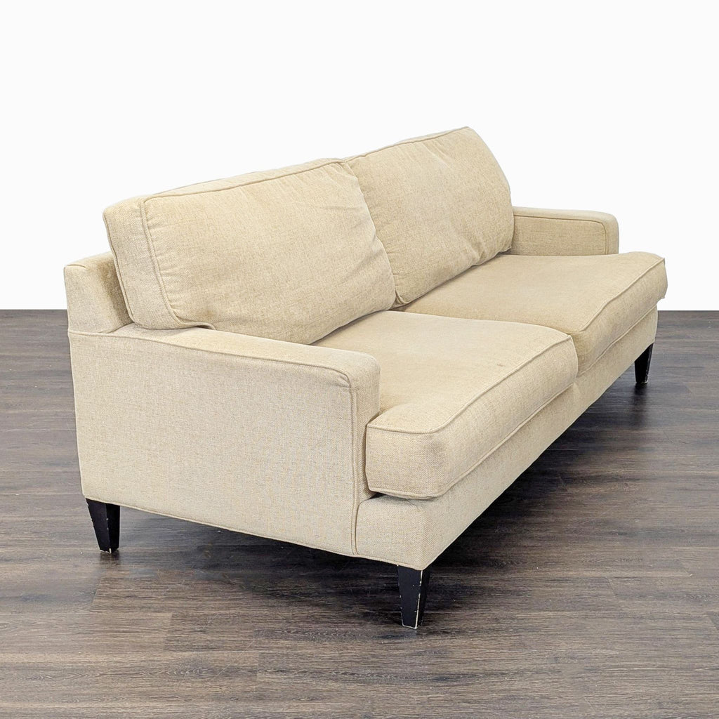 Angled view of a neutral beige 3-seat Pier 1 Imports sofa with clean lines and sturdy dark legs.  