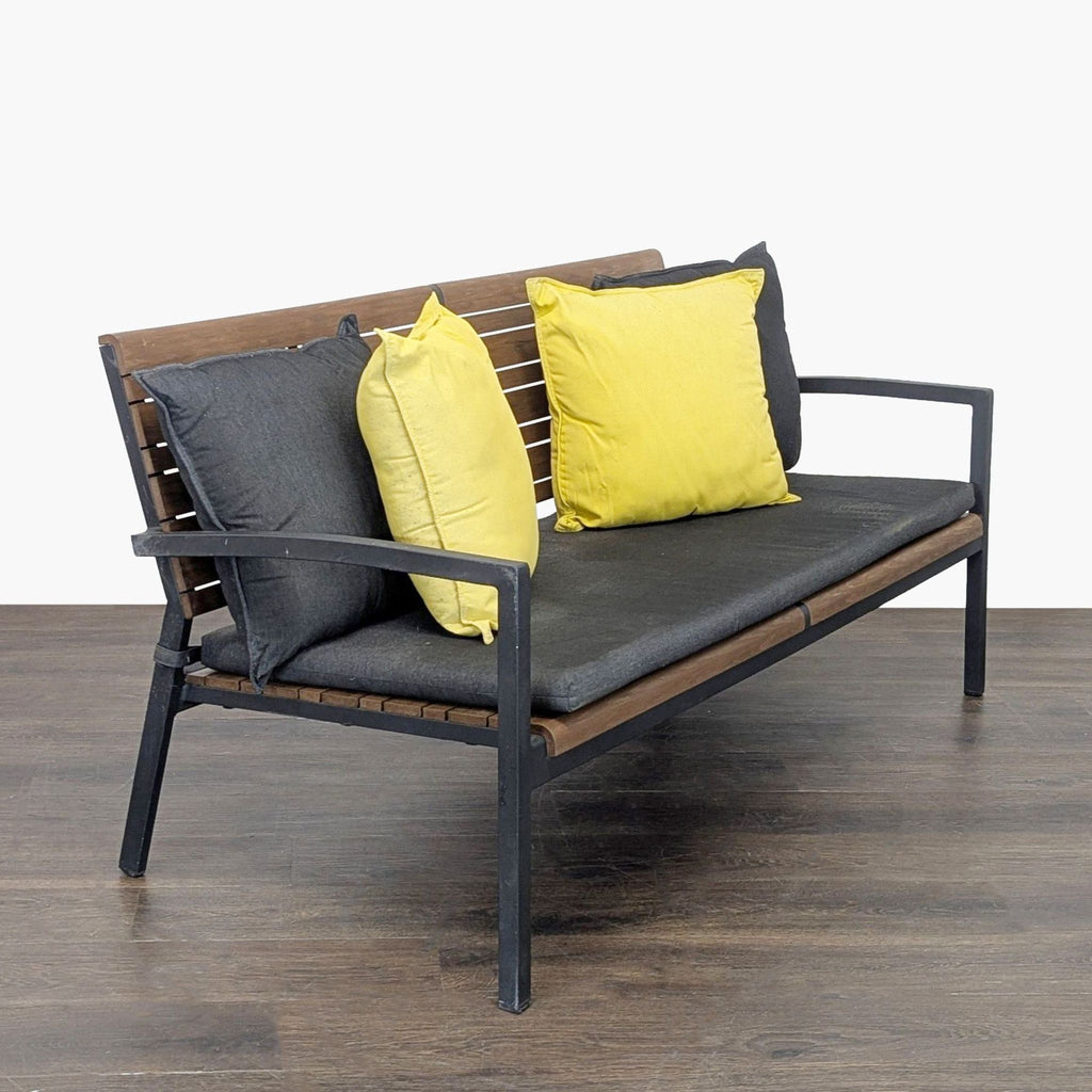 Modern bench from Crate & Barrel with wooden slats, black metal frame, and comfy yellow and grey cushions.