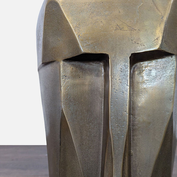 Geometric face sculpture stool with metallic bronze finish, ideal as an accent table or artistic décor piece.