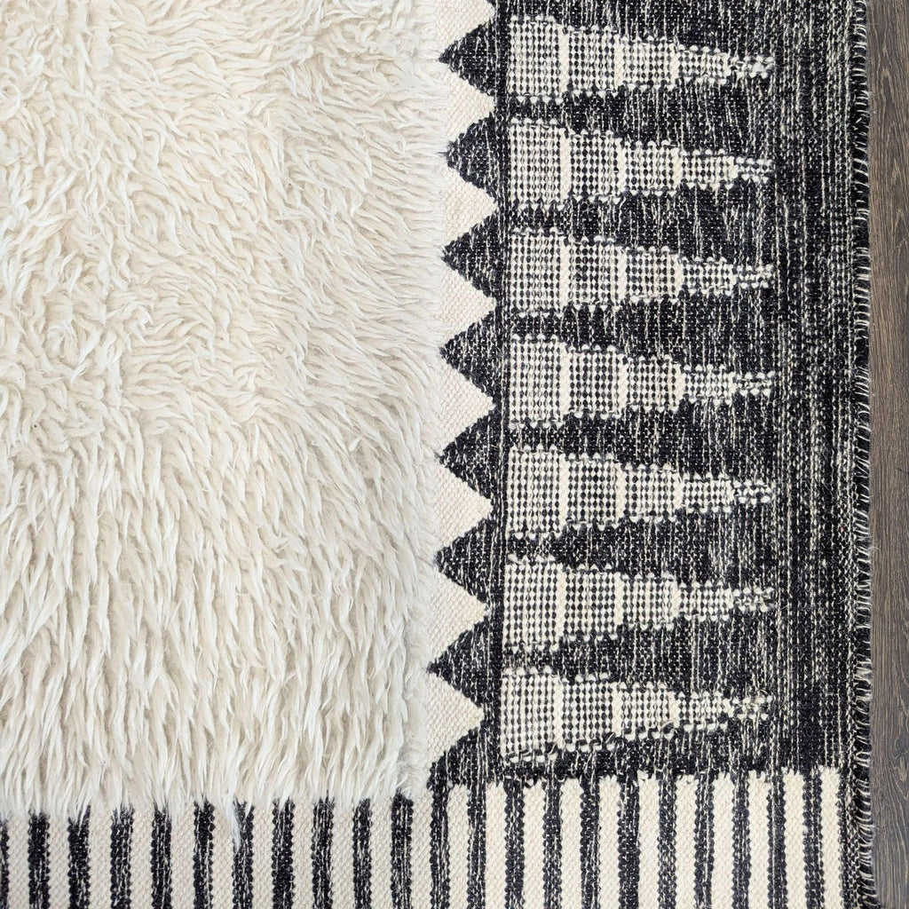 Black and white rug by West Elm featuring a shaggy center, striped edges, and bold triangle accents.