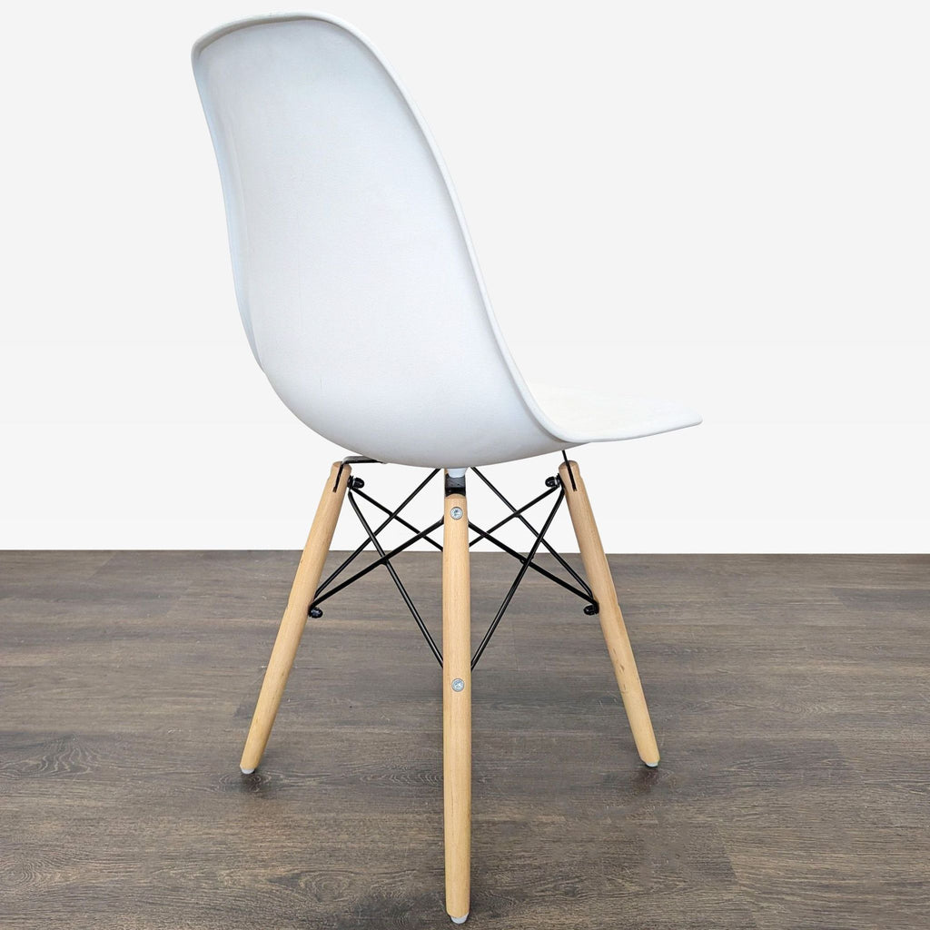Modern dining chairs with curved molded seats, sleek wood legs, and distinct black metal cross bases.