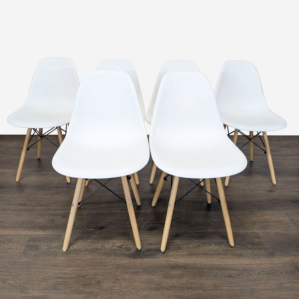Set of Mid-Century Modern dining chairs with molded plastic seats and wood legs featuring black chrome bases.  