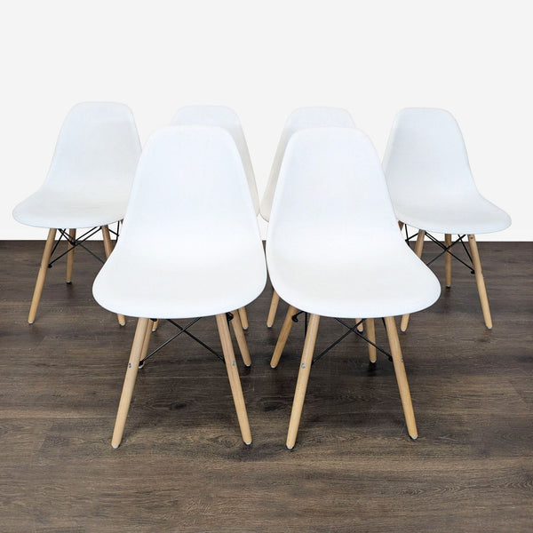 Set of Mid-Century Modern dining chairs with molded plastic seats and wood legs featuring black chrome bases.  