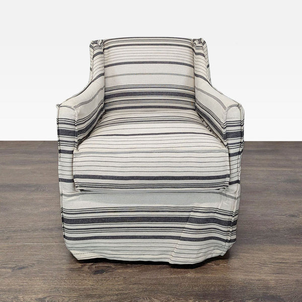 Striped gray and cream lounge armchair with skirted bottom and armrests, perfect for cozy living spaces.
