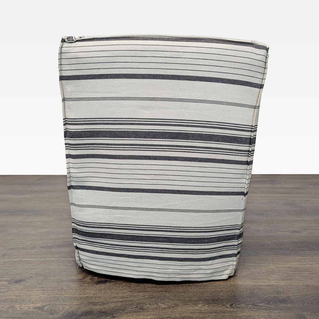 Gray and cream striped armchair with a draped skirt, ideal for relaxing or adding style to your lounge area.