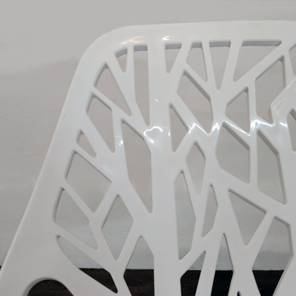 Modern chairs in white with branch-patterned backs and seats, sturdy metal legs, perfect for kitchen or office spaces.
