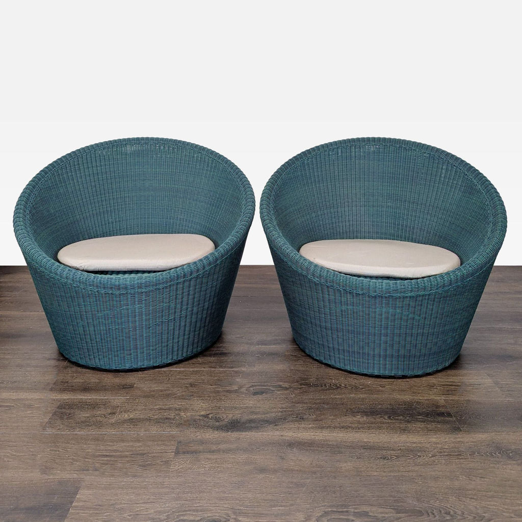 Set of two Crate and Barrel blue woven lounge chairs with beige cushions, ideal for indoor or patio use.