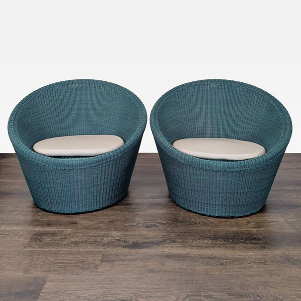 Set of two Crate and Barrel blue woven lounge chairs with beige cushions, ideal for indoor or patio use.