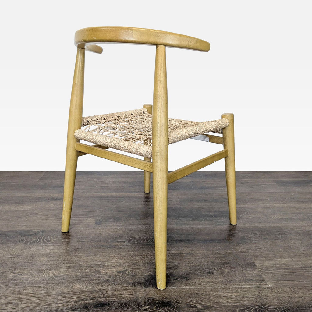 3. Angled side view of a wooden dining chair with a woven rope seat and rounded backrest.